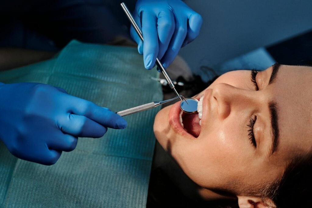 Close-up of a dentist examining a patient's teeth using dental tools.
